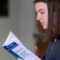 Scholar reading abstract book.